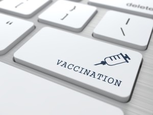 Vaccination Word with Syringe Icon - Button of White Modern Computer Keyboard. Medical Concept.